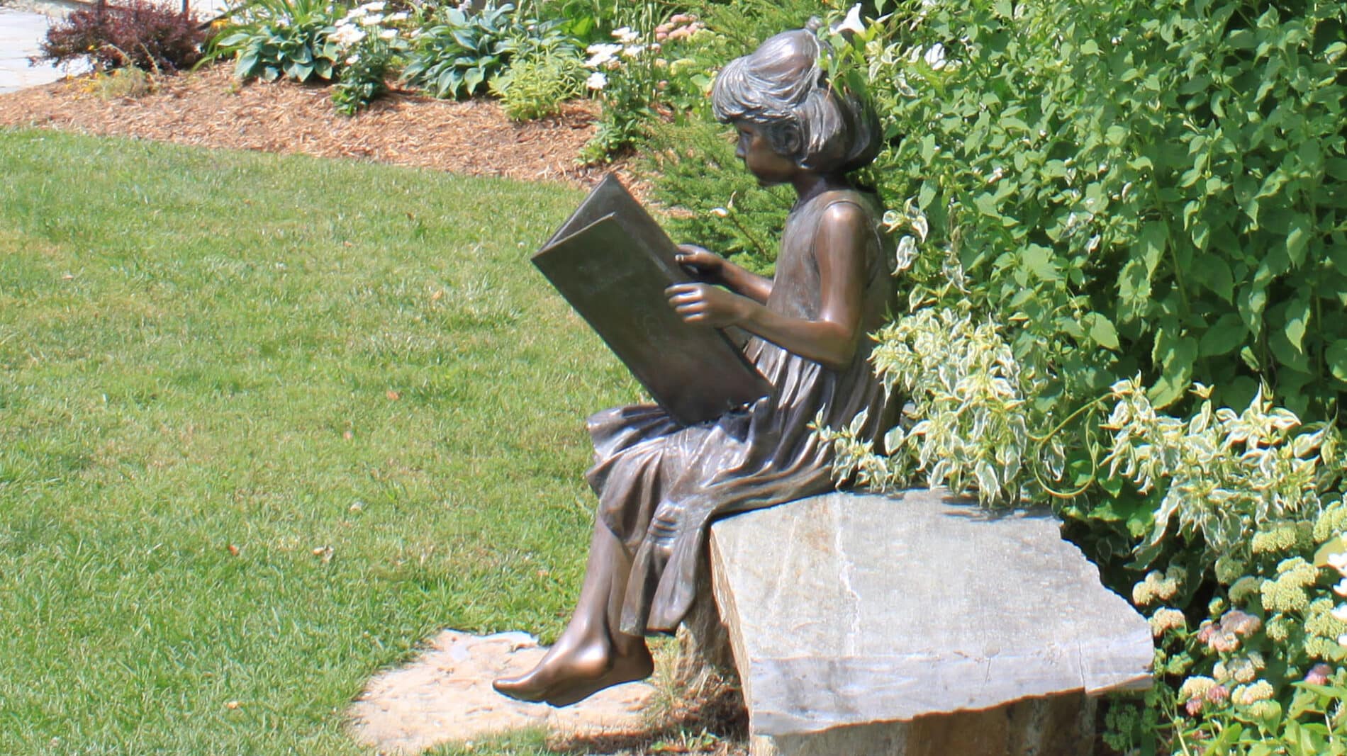 sculpture of little girl reading