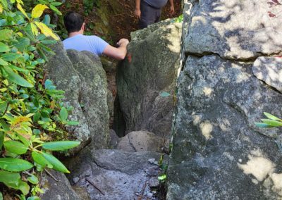 Two men follow a trail over and between large boulders
